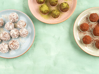 Three different taste energy balls in dishes, cocoa, coconut, matcha