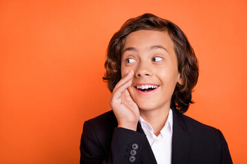 Photo of young brunette happy positive dreamy amazed boy look empty space say news isolated on orange color background