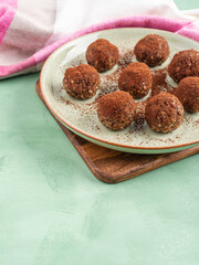 Chocolate cocoa energy balls with nut butter on green dish