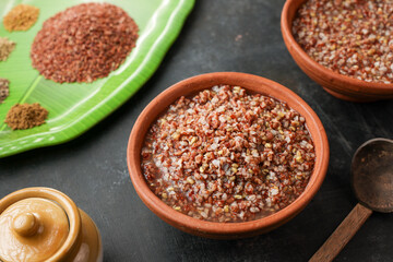 Ayurvedic porridge, Karkidaka Kanji herbal gruel in clay pot black background Kerala South India. Ayurveda diet health drink for immunity, cleanse the body. Top view medicinal porridge Indian veg food