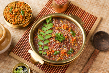 Ayurvedic porridge, Karkidaka Kanji herbal gruel in brass golden bowl Kerala South India. Ayurveda diet health drink for immunity, cleanse the body. Top view medicinal rice porridge Indian veg food