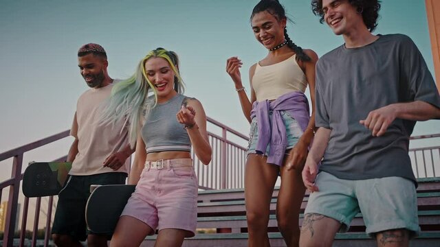 Happy diverse friends with unusual appearance walking together, talking and laughing, feeling free, slow motion