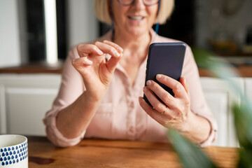 Close up of senior woman using smart phone at home