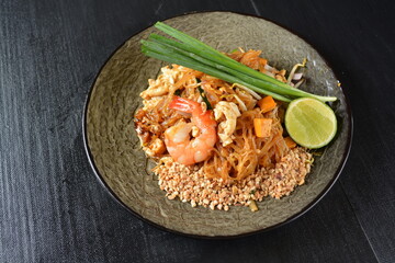 stir fried kway teow rice noodle phad thai with mixed seafood and vegetables in black background healthy asian halal menu