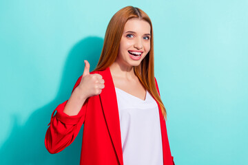 Photo of shiny charming orange hair woman dressed red jacket showing thumb up isolated cyan color background