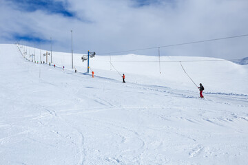 snowboarders and mountain-skiers rising the mountain in russian polar ski resort