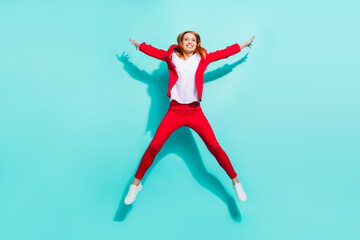 Photo of impressed sweet orange hair lady wear red blazer smiling jumping high like star isolated cyan color background