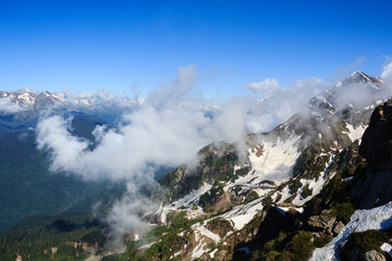 clouds cover peak or the mountain and forest valley in caucasus