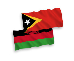National vector fabric wave flags of Malawi and East Timor isolated on white background. 1 to 2 proportion.