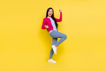 Fototapeta na wymiar Full size photo of hooray brunette young lady hands fists wear pink sweater jeans isolated on yellow background
