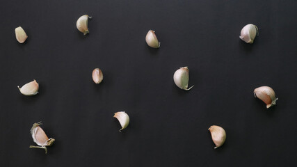 Top view of garlic with dry skin on black background
