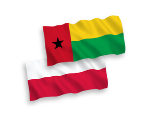 National vector fabric wave flags of Republic of Guinea Bissau and Poland isolated on white background. 1 to 2 proportion.