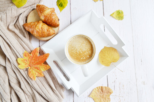 Cup of coffee with autumns leaves, diary and book on the white wooden texture.  September, October. November. Relaxing atmosphere.  Quarantine stay home. 