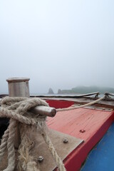 the bow of the ship with rope in the foggy morning