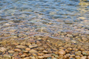 summer sea water transparent surface clear sea brown stone beach 
