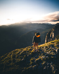 Hiker stand on Mountain Peak watching the Sunset in Austria