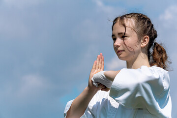 teenage girl training karate kata outdoors, greetings oss