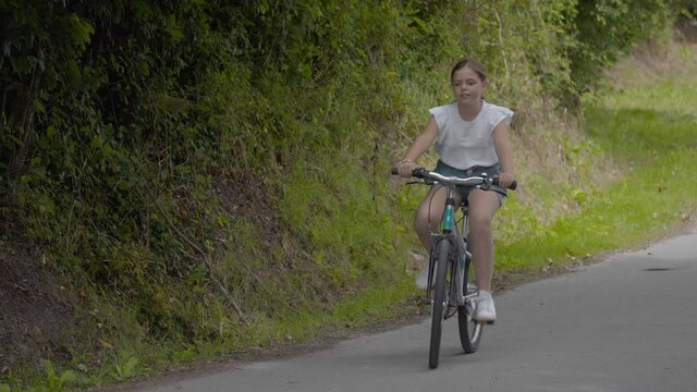 young girl riding a bicycle in summer