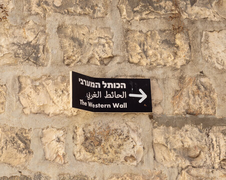 A sign  in three languages - Hebrew, Arabic and English, indicating the direction to the Western Wall, on the wall in Armenian quarter in old city of Jerusalem, Israel