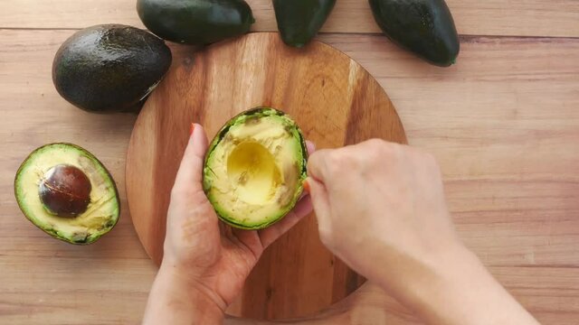 close up of slice of avocado on women's table 