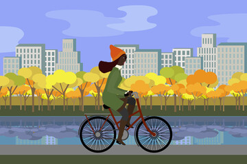 Woman in coat in the park riding bicycles in autumn