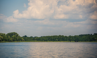 Low angle shot of the beautiful sky captured from a lake in a field