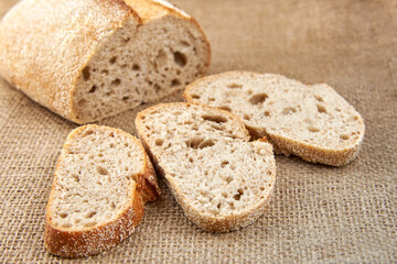 Pieces of sliced freshly baked bread on burlap.