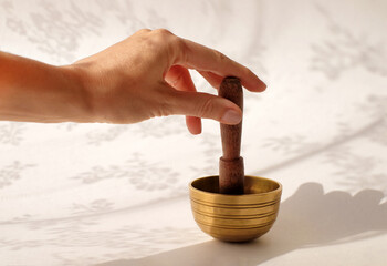 Himalayan tibetian singing bowl and hand on white abstract background