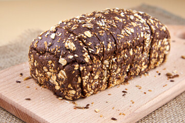 Dark rye bread with whole sunflower seeds, flaxseeds and oatmeal on top.