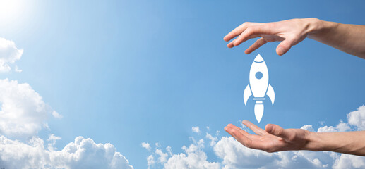 Male hand holding rocket icon that takes off, launch on blue background. rocket is launching and flying out, Business start up, Icon marketing on modern virtual interface.Start up concept.