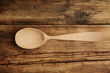 Handmade wooden spoon on rustic table, top view