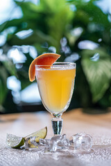 lemonade in glass or refreshing drink with grapefruit, lime and ice on table