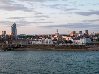 view of Old Portsmouth England from the sea at dusk as the sun sets