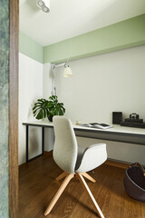 Stylish home office interior in modern apartment with desk, armchair and other office and personal accessories. Sunny space with white and mint walls. Details. Template..