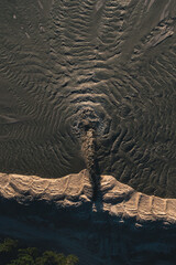  Flow of dirty water with sand during the extraction of sand. Waves disperse on the surface of...