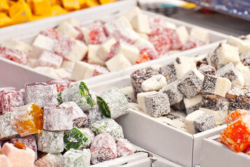 Turkish national sweets are sold at the fair. Multi-colored Asian desserts stacked on the table. Rahat lokum in bulk is sold at the festival.