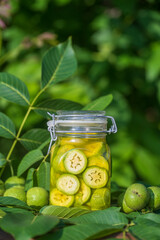 Sliced unripe walnuts in alcohol in a jar, to prepare homemade tincture, close up