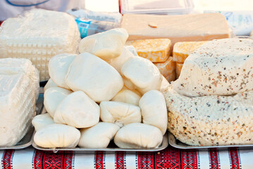Different types of cheese on the table. Many cheese is sold at an agricultural fair. Natural home product.