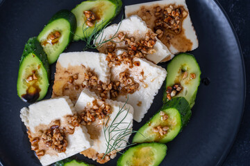Fresh salad with green cucumber and white cheese with olive oil sauce and roasted almonds