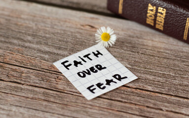 Faith over fear. Inspiring handwritten quote from the Bible Book. Trust, faith, hope, belief in God and Jesus Christ. Devoted faithful Christian biblical concept. A closeup.