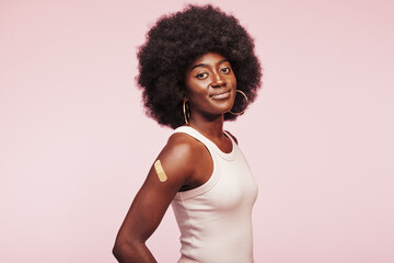 Young African woman with a vaccine shot bandage