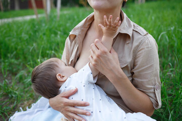 baby boy sucking milk from mothers breast. Portrait of mom and baby.