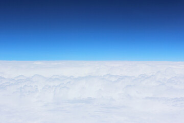 Cloud and sky pastel colors abstract nature background. airplane and green landscape, river, mountain, clouds background. View from the airplane window. Airplane wing flying above the clouds. Top view