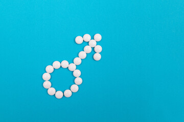 Male Gender Symbol Made from White Pills - Men's Health and Medicine, Medicaments for Men, Lying on Blue Background. Copy Space