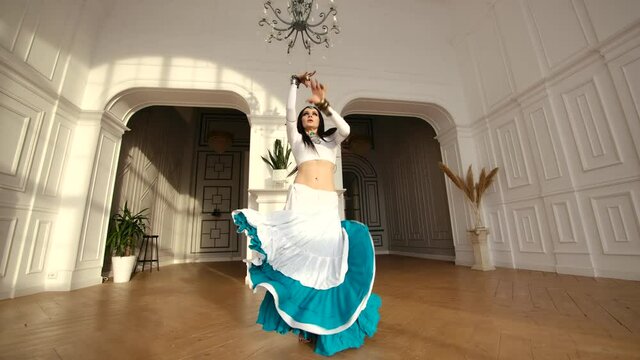 Dancing Girl in Beautiful Eastern Ethnic Dress. Sensuality in Belly Dance with Artistic Expressive Move One Woman. Festive Activity Expressions in Asian Tradition. Bright Oriental Costume on Performer