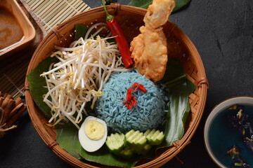Nasi kerabu or nasi ulam, popular Malay rice dish. Blue color of rice resulting from the petals of butterfly-pea flowers. Traditional Malaysian food, Asian cuisine.