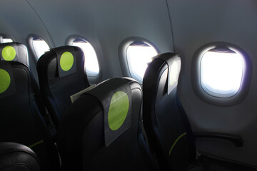 aircraft cabin, seats, portholes, empty plane without passengers. Rows of gray leather seats and...