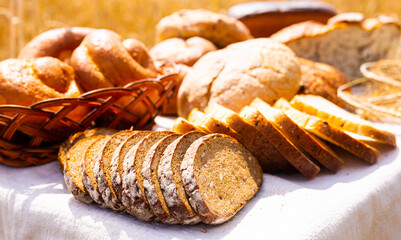 lot of different flavored bread, wheat, rye, on the table in the field outside