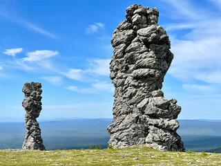 Stone pillars of weathering on the Manpupuner mountain plateau in the Komi Republic in Russia in summer. Rocks Monkey and Queen