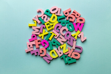 Multicolored small letters scattered in a chaotic close-up on a colored background. concept of elementary school teaching children. back to school